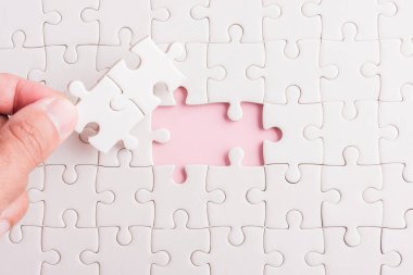 Üst görünüm düz konum son parça beyaz kağıt yapboz oyunu çözülmesi için yerleştirilen son parçalar tam görev, pembe arka plan üzerine stüdyo çekimi, quiz hesaplama konsepti