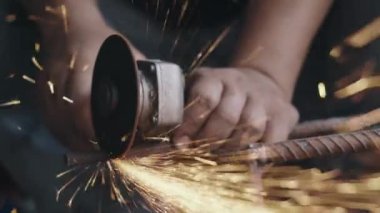 Elektrikli tekerlek öğütme ve çelik yapıyı kesme kullanan işçiler, endüstriyel üretim çarkından kıvılcımlar çıkardılar.