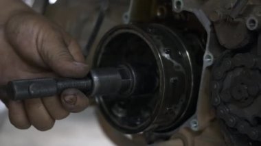 Tamirci manyetiksel tekerlekleri söküyor. Motosiklet tamircisinin fındığını söküyor. Motosiklet tamircisi.