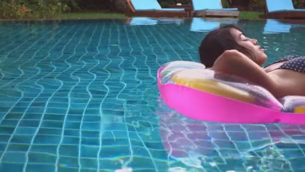 豪華なホテルのスイミングプールで膨脹可能な空気マットレスでリラックスしたビキニのアジアの美しい若い女性 日焼けを楽しんでいる女性 夏の旅行休暇のコンセプト — ストック動画