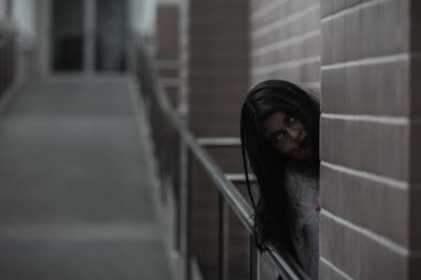 Evdeki karanlık bir odada korkunç kötü kadın hayaleti. Kan içindeki dişi zombi korkunçtur. Terk edilmiş binaya musallat oldu. Mutlu Cadılar Bayramı festivali konsepti.