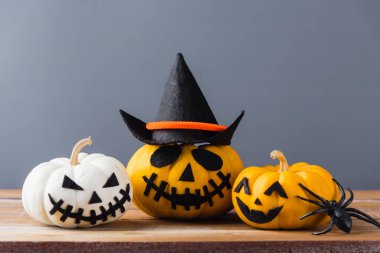 Komik Cadılar Bayramı dekorasyon partisi, Cadılar Bayramı balkabağı kafası yakın plan Jack o fener gülüşü korkutucu ve örümcekler ahşap ve fotokopi alanı, izole edilmiş gri arka plan, Mutlu bayramlar konsepti