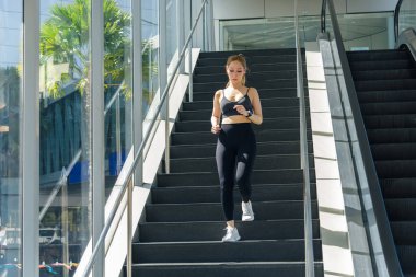 Formda bir kadın spor yaparken, dışarıda spor yaparken, merdivenlerden inerken, sağlıklı bir şekilde yaşarken, formda fizikte, esnek ve aktif insanlara ilham verirken,.