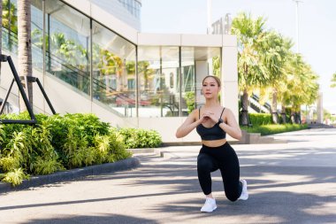 Formda bir kadın, açık havada spor egzersizi, hücum eğitimi, formda vücut, güneş altında sağlıklı aktif yaşam tarzı, modern mimari ile kentsel çevre..