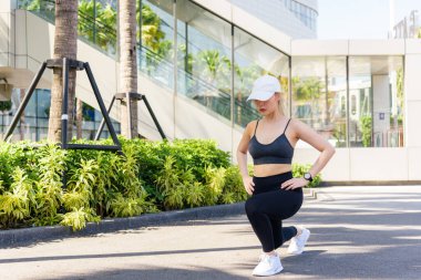 Esnek kadın dışarıda spor egzersizi yapıyor, fit kadın sağlıklı aktif yaşam tarzını sürdürüyor, tüm vücudunu esnetme rutini şehir ortamındaki insanların sağlığını arttırıyor..