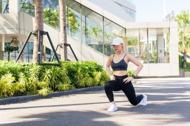 Spor kadını dışarıda egzersiz yapıyor, fit insanlar antrenmandan zevk alıyor, şehir ortamında esneme rutini günlük sağlıklı yaşam tarzını destekliyor..