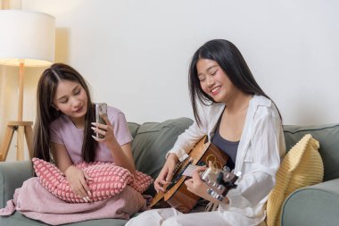 Genç bir kız arkadaşıyla gitar çalıyor. Telefon çalıyor, genç bir kadın müzik hobisinden hoşlanıyor. Rahat bir ev paylaşıyor, neşeli anlar yaşıyor..