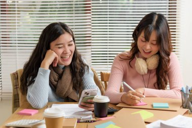 Meşgul insanlar tanışıyor, ofiste çalışıyor, finans ekibi danışmanlığı yapıyor, genç iş kadınları işbirliği yapıyor, yaratıcı projeler için fikirlerini paylaşıyor, belgelerle verimli çalışma oturumundan ve sıcak kahveden keyif alıyor.