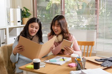 Yoğun insanlar ofiste toplanıyor, mali işler üzerinde danışmanlık yapıyor, genç iş adamları proje belgelerini odaklı bir şekilde tartışıyor, başarılı bir ortaklık ve strateji gösteriyor.
