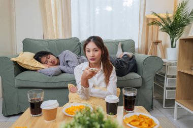 İki genç kadın, arkadaşlar, evde dinlenmenin tadını çıkarın, lezzetli atıştırmalıklar yiyin, içkilerinizi tazeleyin, en sevilen eğlenceyi izleyin, sıcak oturma odasında birlikte kaliteli zaman geçirin..