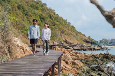 Seyahat eden çiftler rahatlamak için mutlu tatiller geçirirler, doğa maceralarını keşfederler kayalık sahil şeridi boyunca yürürler, okyanus manzaraları, yeşil tepeler, açık gökyüzü..