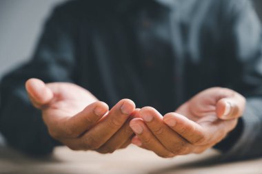 Parmakları açık, yakın çekimde, izleyiciye doğru uzanıyordu. Elleri yumuşak ve soluk, manikürlü tırnakları var. Arka plan bulanık..