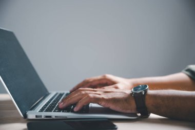 Laptop klavyesinde kol saati ile yazı yazan ellerin yakın çekimi. .