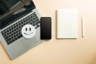 Müşteri değerlendirmesi ve dizüstü bilgisayar, dijital telefon anketi, müşteri memnuniyeti değerlendirmesi, modern akıllı telefonun yanında mutlu simge, boş defter, olumlu yorumlar için kalem.