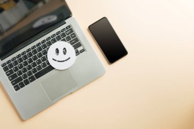 Müşteri değerlendirmesi çevrimiçi dizüstü bilgisayar değerlendirmesi için geri bildirim, dijital tatmin anketi için gülen surat sembolü, anlık veri yakalama için modern bilgisayar ayarlarının yanında oturan telefon aygıtı.