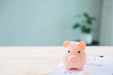 Piggy Bank finans para belgeleri yönetim çek belgesini kaydet, ahşap masa profesyonel iş yatırımları ve bütçe hedefleri analizi için bulanık arka plan kopyalama alanı sağlar.