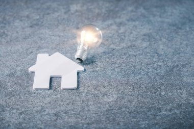 Emlak evi aile mülkü için ampul kullanan ev, ipotek komisyoncusu bilgisi için ampul konsepti elektrik faturaları ve yeşil enerji verimliliğinden tasarruf edilmesine yardımcı oluyor.