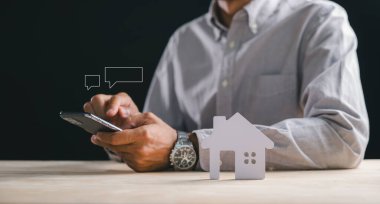 Ev konsepti, kişi cep telefonu kullanarak emlak piyasasını araştırıyor, yeni ev listelerini araştırıyor, konut kredilerini dijital olarak satın almak veya satmak için güvence altına alıyor.