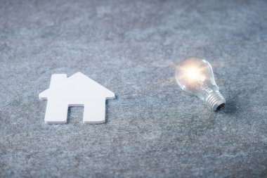 Beyaz Saray modeli ve parlayan ampul emlak enerjisini temsil ediyor, aile ipoteği emlak komisyoncusu bilgisi, elektrik enerjisinden tasarruf etmek için ampul konsepti.