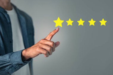 Ekranda gösterilen iyi bir reyting için el sıkışarak beş yıldızlı değerlendirme oranı kavramı, saygın bir müşteri deneyimi gösteren olumlu geri bildirimi yansıtıyor.