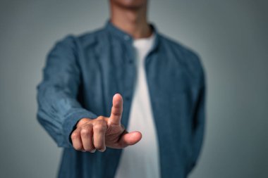 Özel bir pozda poz veren bir adam, iş için kullanılan bir jest veya işaret, parmağını sanal ekrana ya da interaktif bir ekrana dokunurken gösteren odaklanmış bir poz..