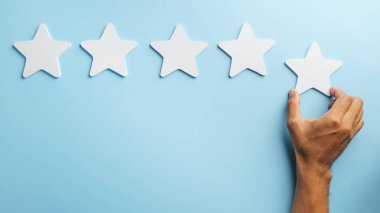 Müşteri geribildirimi, beşinci yıldızın elle yerleştirilmesi, olumlu değerlendirme, mükemmel hizmet memnuniyeti kavramı, müşteri memnuniyeti iş kalitesi ve en yüksek derecelendirme.