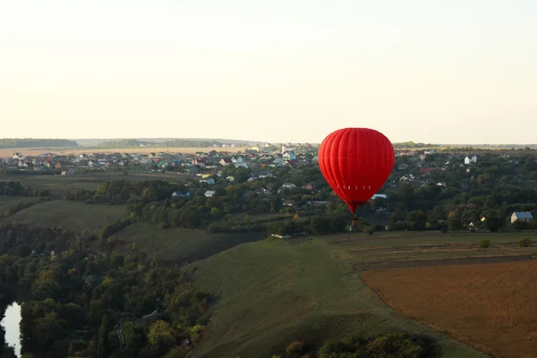 Hot air balloon (aerostat) over green fields — Stock Photo, Image