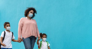 Mother with son and daughter wearing face protective mask going back to school during corona virus pandemic - Healthcare and education concept clipart