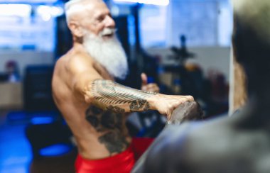 Farklı yaş ve ırka sahip sporcular spor salonunda bisiklet egzersizleri yapıyorlar - Spor etkinliği ve fitness yaşam tarzı konsepti
