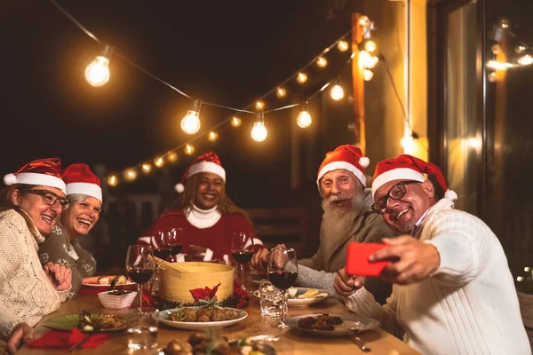 Happy Senior Friends Dining Celebrate Christmas Vacation While Taking Selfie — Stok Foto