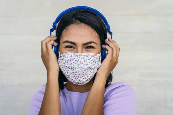 Mujer Joven Con Mascarilla Facial Escuchando Música Con Auriculares Inalámbricos — Foto de Stock