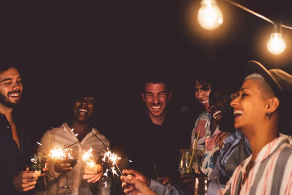 快乐的年轻朋友们在新年前夕燃放焰火 在天井别墅派对上喝鸡尾酒 年轻人的生活方式和度假理念 — 图库照片
