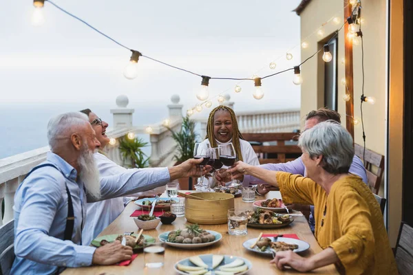 Happy Multiracial Seniors Toasting Red Wine Glasses Together House Patio — Stock fotografie