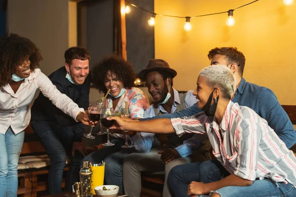 パティオハウスパーティーでカクテルや赤ワインを楽しみながら休暇中に楽しい多人種間の友人 — ストック写真
