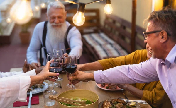 Mutlu Çok Irklı Kıdemli Arkadaşlar Kırmızı Şarap Kadehleriyle Verandası Yemeğinde — Stok fotoğraf