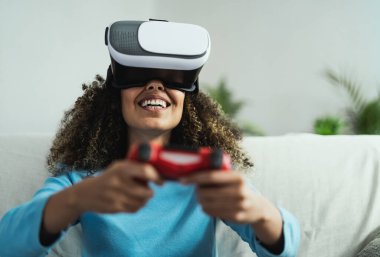 Çevrimiçi video oyunları oynayan genç Afrikalı kadın - Sanal gerçeklik deneyimi olan yeni teknoloji konsolunda eğlenen mutlu oyuncu - Gençlik çağının yaşam tarzı ve teknoloji kavramı