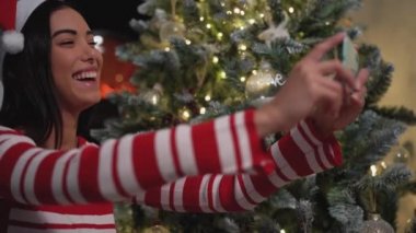 Mutlu genç kız, Noel tatilinde cep telefonu uygulaması kullanarak ailesiyle video görüşmesi yapıyor.