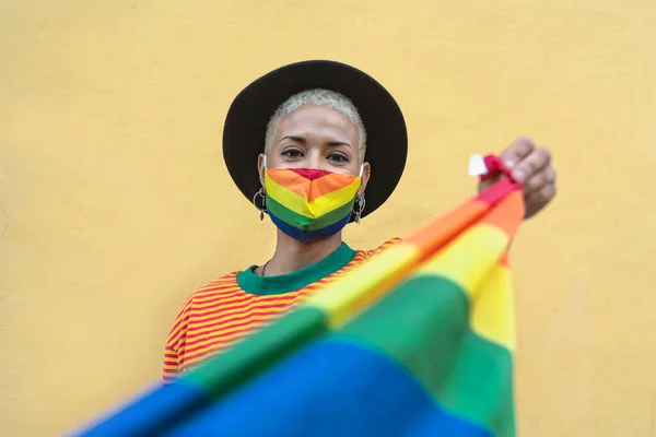 年轻女子戴着同志骄傲面具 手持Lgbtq社会运动的彩虹旗标志 — 图库照片