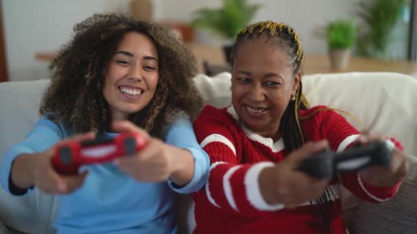 Ευτυχισμένη μητέρα και κόρη που διασκεδάζουν παίζοντας βιντεοπαιχνίδι στο σπίτι - Gaming ψυχαγωγία και τεχνολογία έννοια — Αρχείο Βίντεο