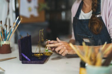 Çömlek atölyesinde boya tozu döken mutlu kadın.