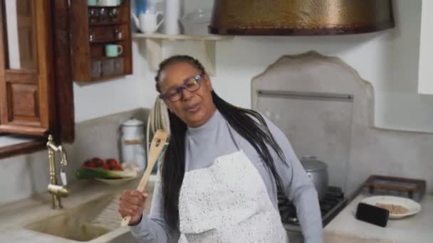 African Senior Woman Having Fun Singing Kitchen While Preparing Homemade — Stock Video