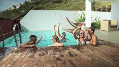 Mutlu arkadaşlar yüzme havuzunda yaz gününün tadını çıkarıyorlar - gençler özel bir villada eğleniyorlar - gençlik tatili yaşam tarzı konsepti