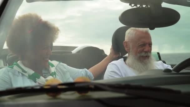新しいコンバーチブル車で楽しい運転をして幸せな高齢者のカップル 成熟した人々は一緒にロードトリップツアー休暇中に時間を楽しんで 高齢者ライフスタイルと旅行文化交通コンセプト — ストック動画