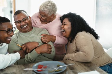 Mutlu Afrikalı bir aile evde öğle yemeğinden sonra eğleniyor. Yemek ve ebeveynler birliği kavramı.