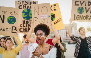 Plastik kirliliği ve iklim değişikliğini protesto eden göstericiler grubu - Çevre felaketleri hakkında pankart tutan çok ırklı insanlar - Küresel ısınma kavramı