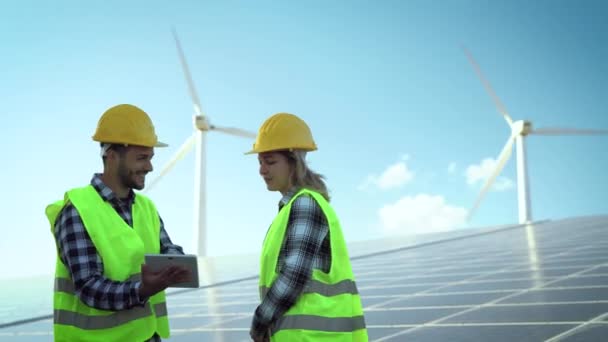 風力発電と太陽光発電パネルで代替エネルギーのために働く人々 革新と緑の電力コンセプト — ストック動画