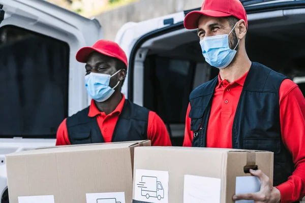 Giovani Uomini Consegna Che Trasportano Scatola Cartone Mentre Indossano Maschera — Foto Stock