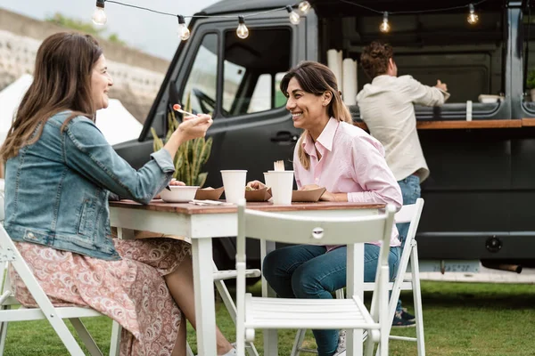 幸せな成熟した女性楽しいを持っていますストリートフードトラック屋外で食べる — ストック写真