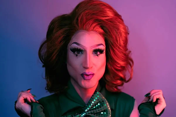 Portrait of drag queen on colored background looking into the camera