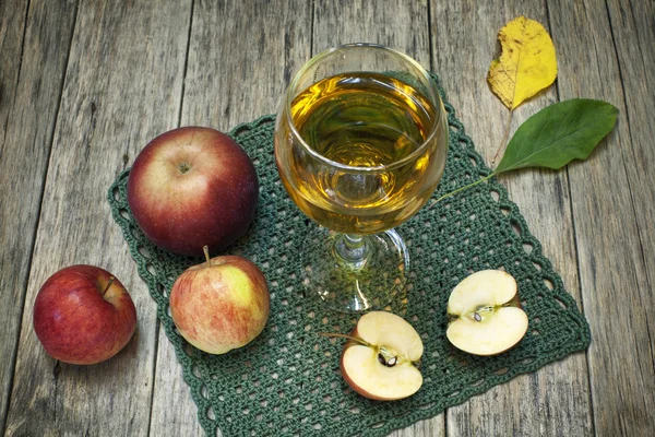 Mooie compositie met SAP in een glas, appels en gevallen bladeren. — Stockfoto